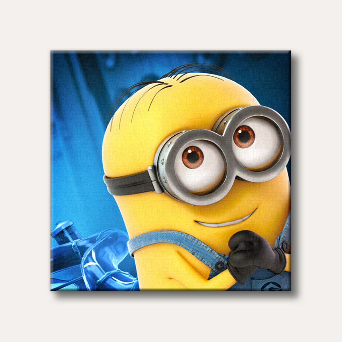 A close-up of a smiling yellow Minion character wearing goggles and denim overalls, set against a bright blue background in a vibrant 3D animated style.