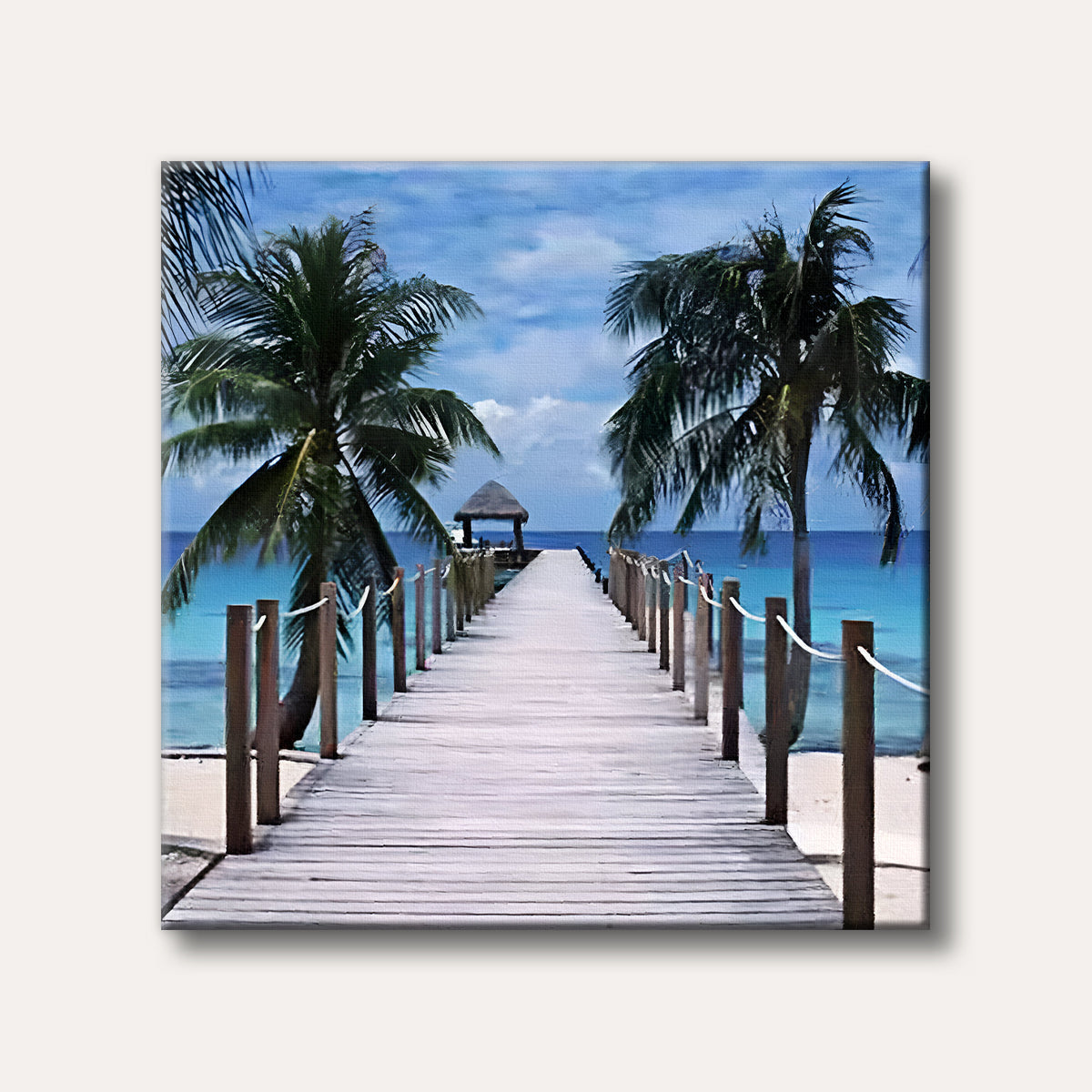 A serene wooden pier extends into clear turquoise ocean water under a blue sky, flanked by lush green palm trees on a white sandy beach, conveying a peaceful tropical scene.