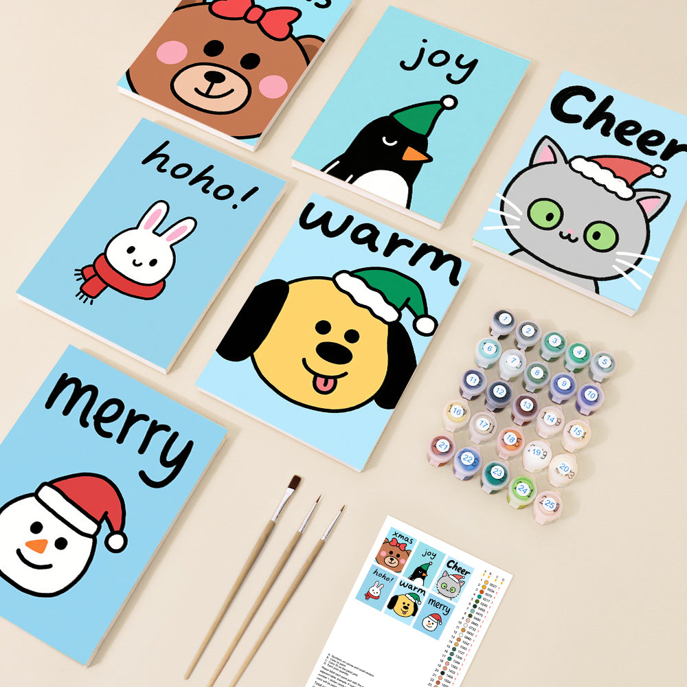 Six small paint by number canvases display adorable cartoon Christmas characters like a bear, penguin, and snowman, each with a festive word and set against a light blue background, accompanied by paints and brushes.