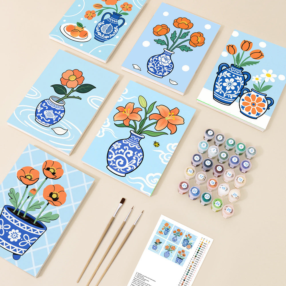 Multiple paint by number canvases display vibrant orange flowers in blue and white chinoiserie-style vases, set against a light blue background in a charming, illustrative style.