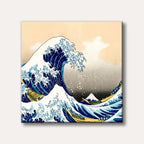 A famous Japanese ukiyo-e woodblock print depicting a massive rogue wave threatening three boats, with Mount Fuji in the background, in a striking blue, white, and beige colour palette.